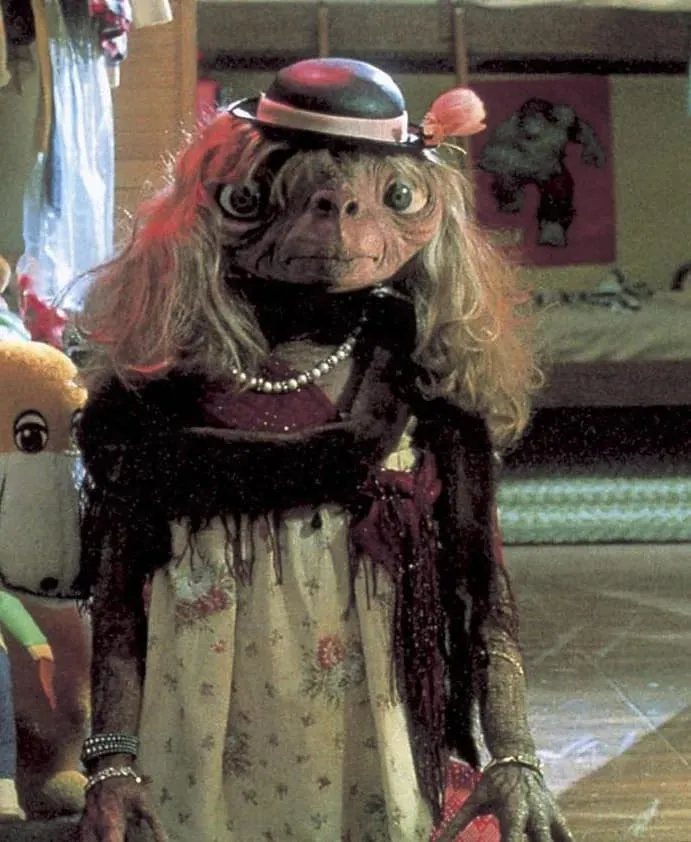 Screenshot from the movie E.T. with E.T. wearing a wig and clothes