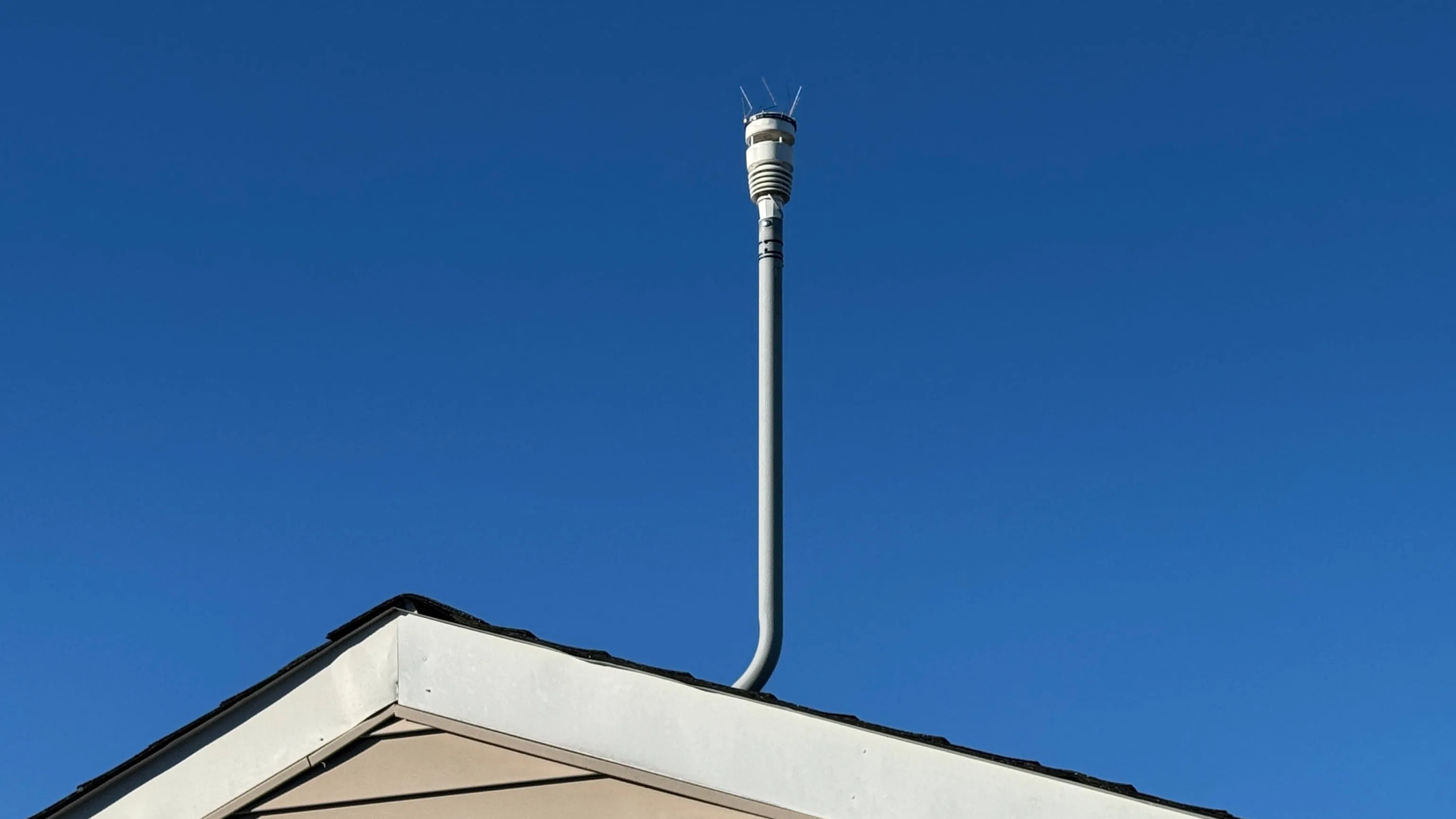 Ecowitt WS90 weather station mounted to a pole on my roof